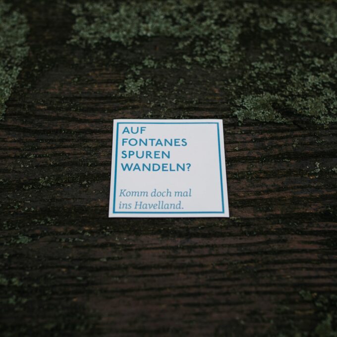 Quadratischer Spruchmagnet in Weiß mit blauer Aufschrift "Auf Fontanes Spuren wandeln? Komm doch mal ins Havelland."